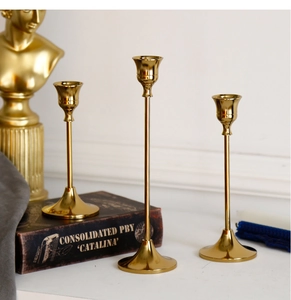 Detailed view of three polished brass candle holders in varied heights for home decor