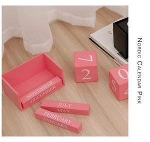 Gros plan sur le calendrier perpétuel nordique en bois rose avec mois et dates