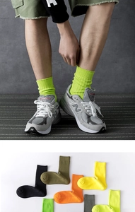 Macro detail of multi-color ribbed crew socks in neon green, orange and grey cotton fabric