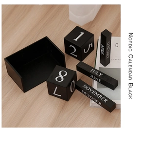 Vue détaillée du calendrier perpétuel nordique en bois noir avec cubes et mois gravés