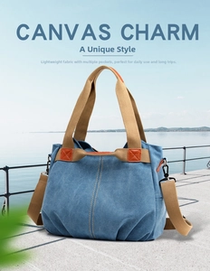 Detail of blue canvas shoulder bag with orange leather accents and durable strap