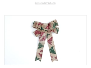 Dettaglio fiocco natalizio in lino da 20cm con motivi di alberi rossi e verdi decorativo