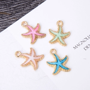 Detail of four colorful enamel starfish pendants in gold-plated frames for jewelry making