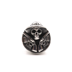 Macro view of vintage stainless steel skull ring with dual revolver pistols and relief detail