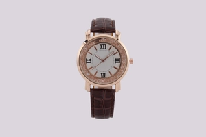 Close-up of rose gold watch case with crystal bezel and brown leather embossed strap