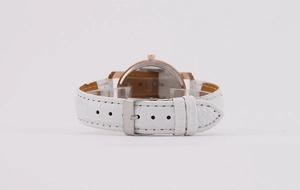Detail view of white crocodile pattern leather strap and rose gold pin buckle