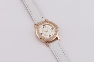 Detail of rose gold watch bezel with rhinestones and white alligator leather strap
