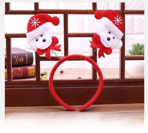 Detail of Christmas headband featuring white plush bears and red spring reindeer antlers