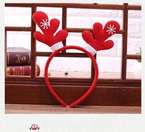 Detail of red plush reindeer antler headband with white snowflake patterns and festive trim