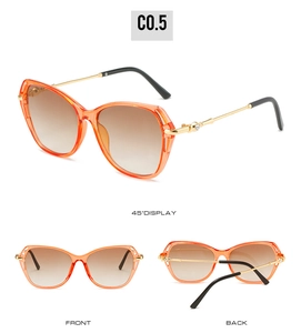 Détail de lunettes papillon orange avec branches en métal et décorations en strass