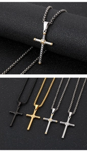 Detail of cross pendants in black, gold, and silver finishes with a box chain on black background