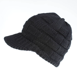 Detail of black chunky knit baseball cap showing the textured 3D plaid pattern and brim