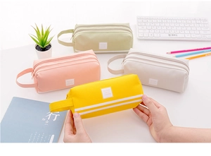 Detalle de estuches de lona de doble capa en amarillo, rosa, beige y verde claro