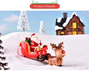 Miniature Christmas Santa on red sleigh and reindeer figurines in a snowy scene