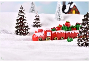 Gros plan d'un mini train de Noël rouge avec cadeaux dans un décor de neige d'hiver