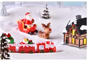 Macro d'un traîneau de Noël et de figurines de train festives en résine rouge