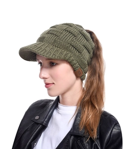 Close-up of army green knitted ponytail hat with cable texture and MOK leather label
