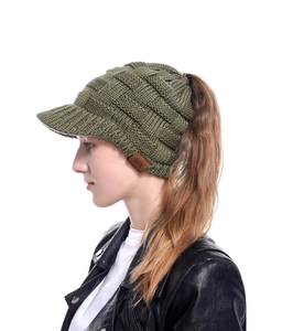 Detail of olive green cable knit ponytail baseball cap with brown leather MOK brand tag