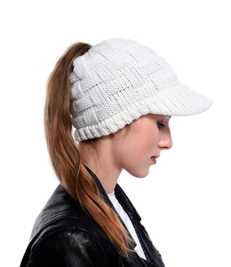 Side view of a white cable knit ponytail sun hat with a practical top opening