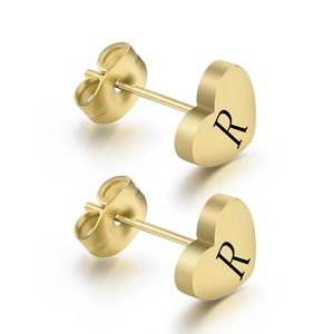 Detailed shot of golden heart stud earrings with engraved letter R and butterfly backs