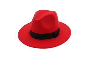 Detailed texture of red wool felt fedora with a contrasting black decorative ribbon band