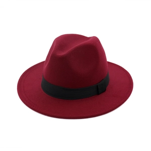 Detail of burgundy wool fedora hat featuring a stylish black ribbon band and flat brim
