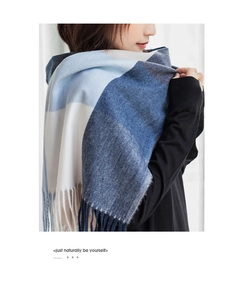 Detail shot of the thick cashmere-feel scarf featuring blue-grey gradient check and tassels