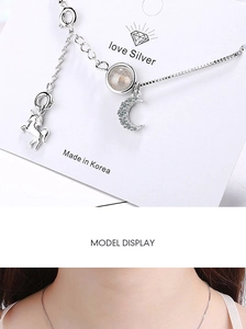 Detail view of unicorn and moon moonstone pendant necklace shown on model and card