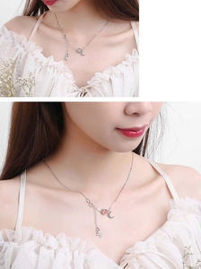 Macro view of moon and unicorn necklace with pink beads on silver chain for women