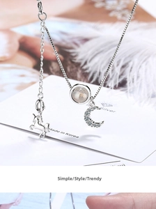 Macro shot of silver unicorn and moon pendant necklace with zircon and moonstone inlay