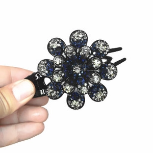 Close-up of a floral hair clip featuring sparkling blue and white rhinestones