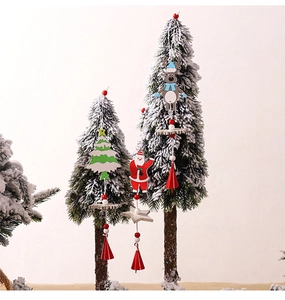 Detail of wooden Christmas ornaments with Santa, tree, reindeer and red bells on pine branch