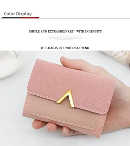 Close-up of pink tri-fold mini wallet with V-shaped gold hardware held by a hand