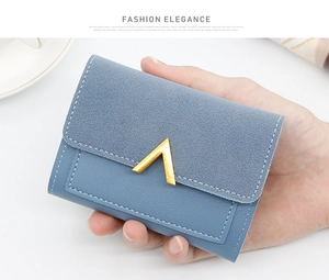 Close-up of Morandi blue suede short wallet for women with golden V-shaped metal trim