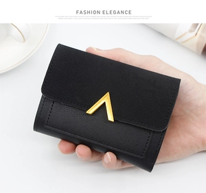 Detail of black tri-fold mini wallet with matte texture and gold V-shaped metal buckle
