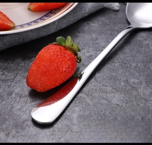 Macro shot of mirror-polished 1010 series stainless steel dinner spoon on stone background