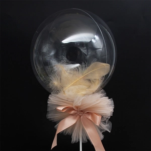 Close-up of a clear balloon filled with beige feathers and a mesh bow detail