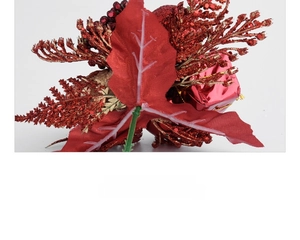 Macro shot of artificial Christmas branch with red glitter leaves and golden ribbons