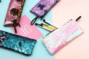 Flat lay of colorful mermaid reversible sequin pencil cases in blue, pink and purple