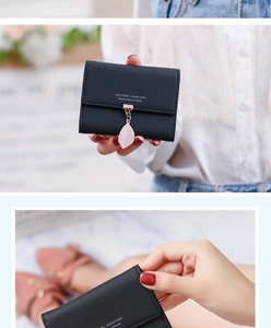 Detailed close-up of a black three-fold card holder featuring a cute pink leaf pendant