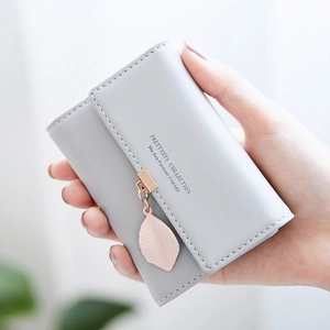 Close-up of a gray textured mini card wallet featuring a cute pink leaf pendant