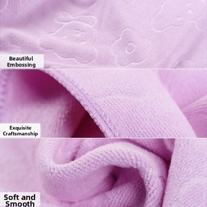 Macro detail of purple microfiber towel showing embossed bear pattern and fine stitching