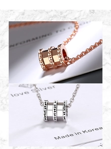 Macro detail of cylinder spiral pendant necklaces in rose gold and silver finish