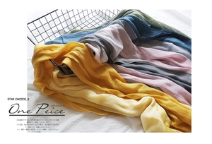 Close-up of lightweight cotton linen scarves with crinkle texture in a vintage basket