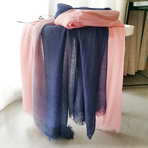Detailed view of lightweight linen blend scarves with fringe edges in navy blue and pink