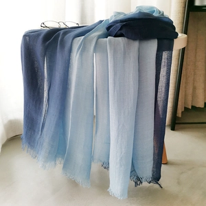 Close-up of gradient blue linen scarf with fringe edges and lightweight texture