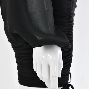 Detail of sheer tulle sleeves and ruched drawstring design on a black bodycon dress