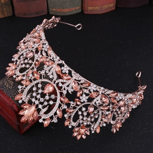 Detailed view of rose gold bridal crown with pink rhinestones and vintage baroque patterns