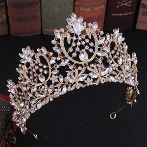 Detail shot of golden baroque bridal crown with crystals set on classical art books