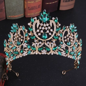Detailed close-up of a vintage golden Baroque crown with luxury green and clear crystals